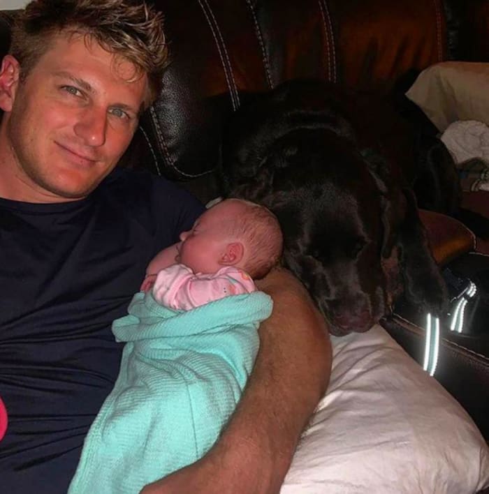 Brittany Lincicome’s husband, Dewald Gouws, holds newborn daughter Emery as Dexter snoozes nearby.